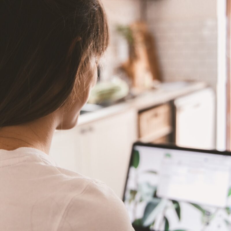 woman in white shirt looking at the computer monitor