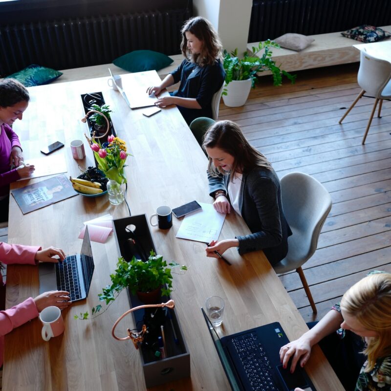 a group of people sitting around a wooden table